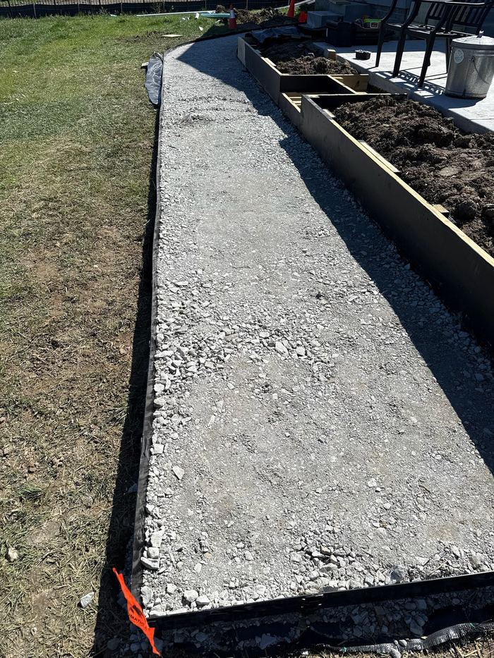 Excavated and compacted stone base for walkway, built to eliminate standing water